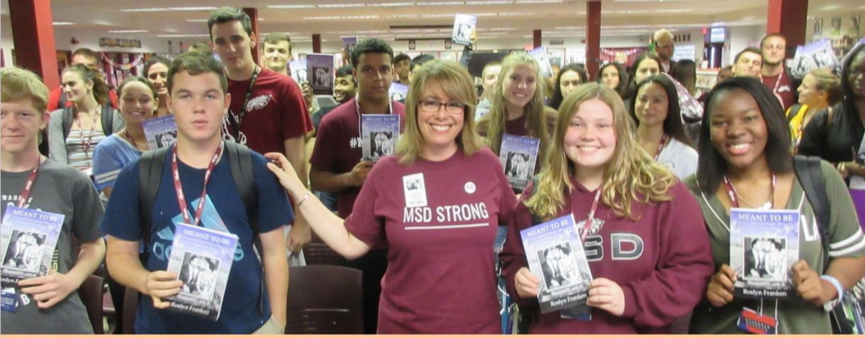 Author Roslyn Franken (centre, wearing glasses) stands with students at Marjory Stoneman Douglas High School in Parkland, Fla, after delivering her presentation and autographed copies of her book to the class shot into by the gunman on February 14, 2018 killing 17 people. 